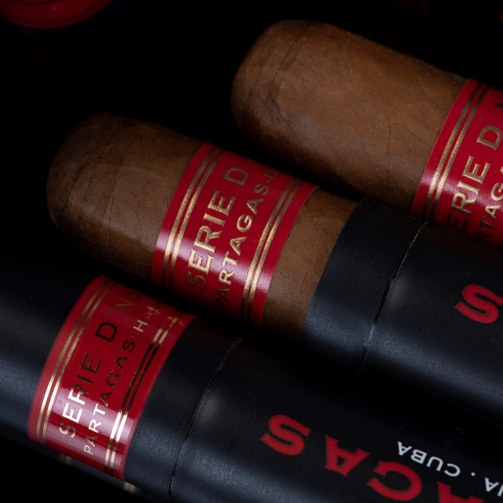 Partagás Serie D No. 4 Tubo mit geöffneter Zigarre auf schwarzem Untergrund