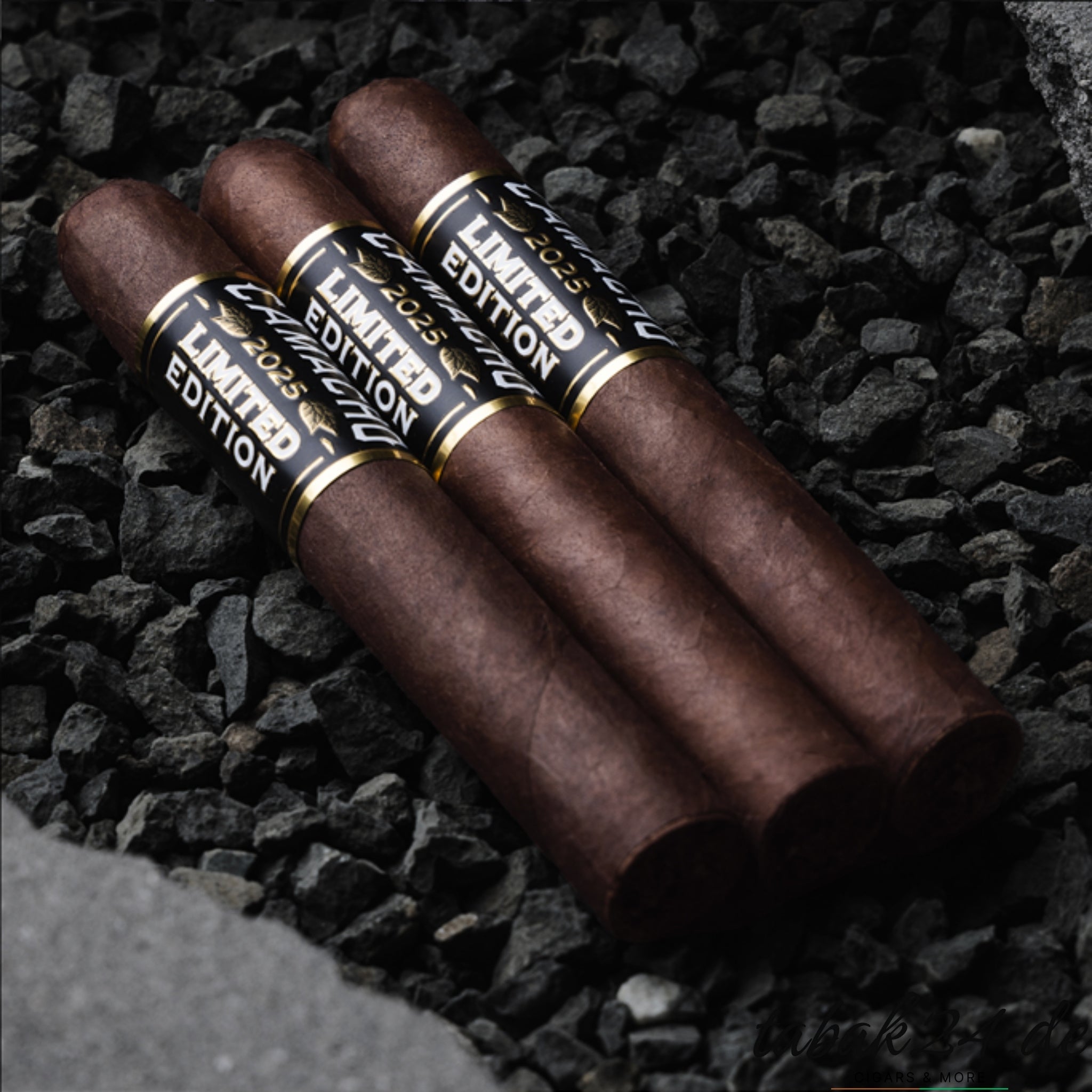 Drei Zigarren der Camacho Limited Edition 2025 auf schwarzem Gestein