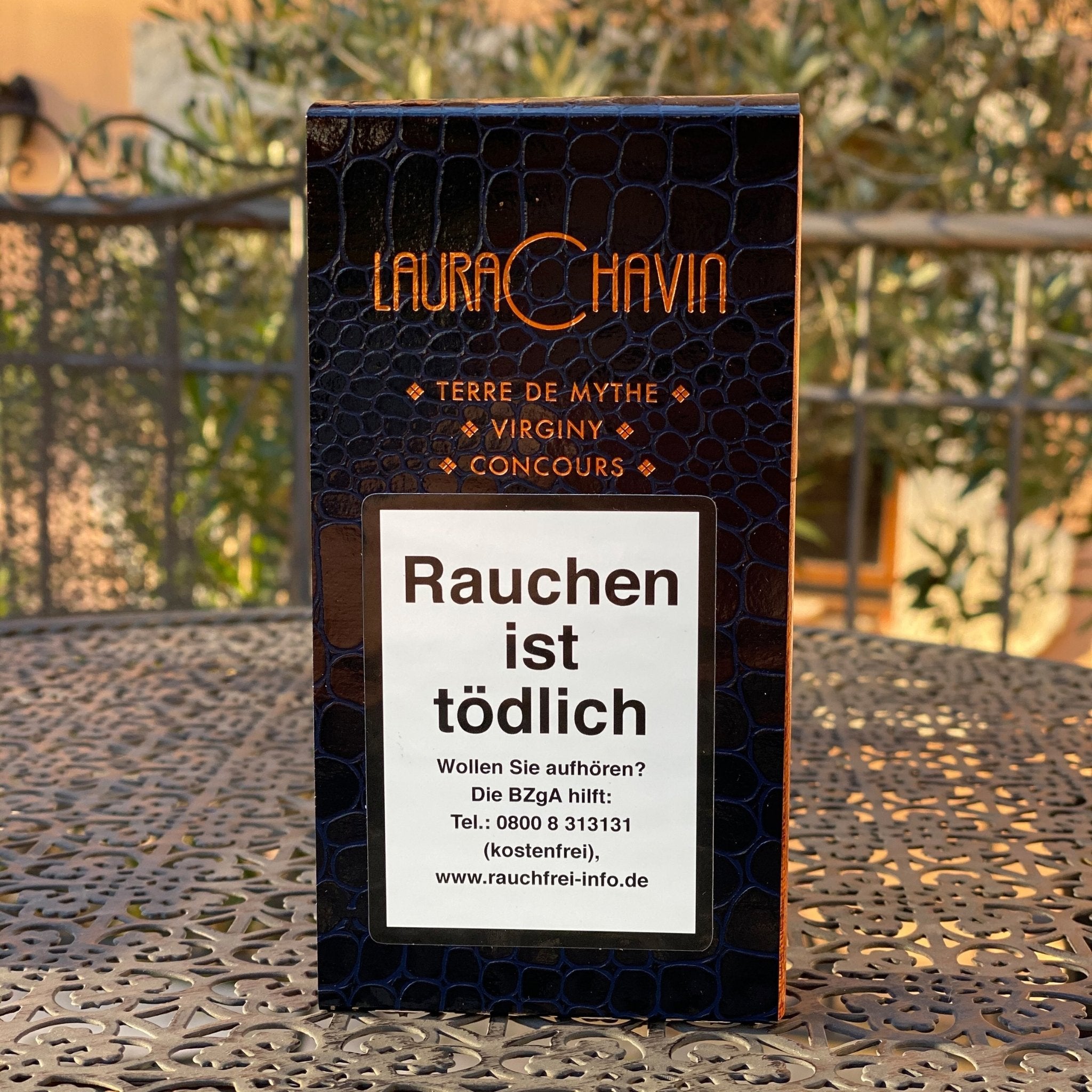 Sampler von 3 Laura Chavin Cigars in Krokodillederoptik auf Metalltisch mit mediterranem Hintergrund