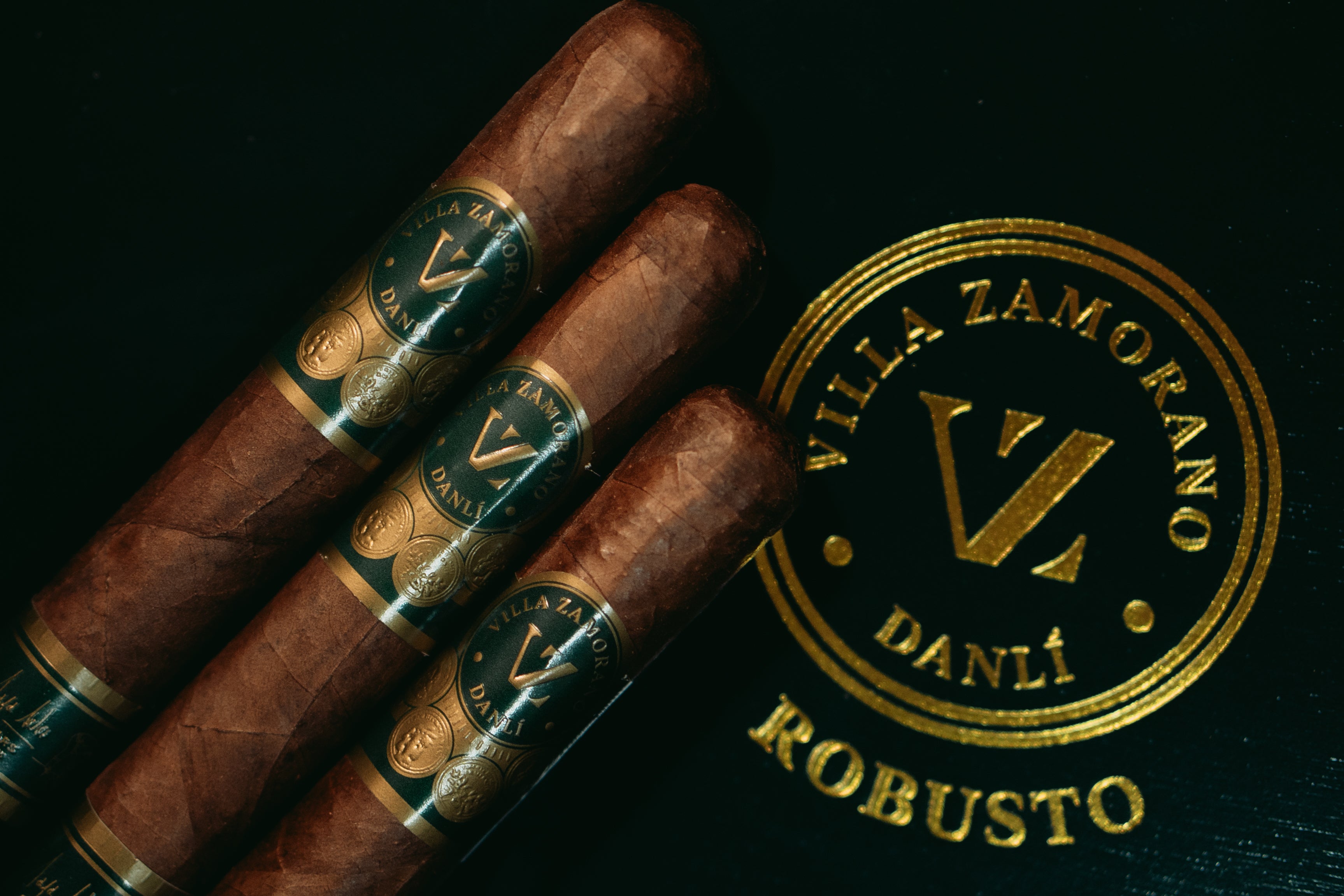 Drei Villa Zamorano Danlí Robusto Zigarren auf goldener Logoprägung